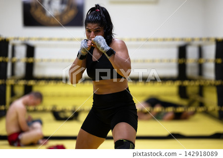 Female Boxer Training in Boxing Ring During Intense Gym Workout and Sparring Session Female Boxer Training in Boxing Ring During Intense Gym Workout and Sparring Session 142918089