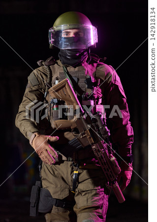 Armed Tactical Soldier in Riot Gear With Helmet Visor and Assault Rifle Under Dramatic Light Armed Tactical Soldier in Riot Gear With Helmet Visor and Assault Rifle Under Dramatic Light 142918134