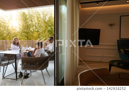 Family Relaxing On Modern Balcony Terrace At Sunset With Laptop And Drinks Family Relaxing On Modern Balcony Terrace At Sunset With Laptop And Drinks 142918252