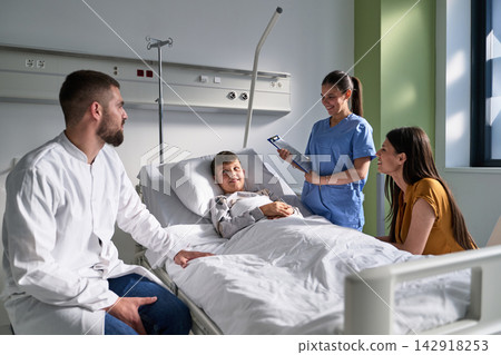 Young boy in hospital bed receives care and support from family and nurse in a modern medical facility Young boy in hospital bed receives care and support from family and nurse in a modern medical facility 142918253