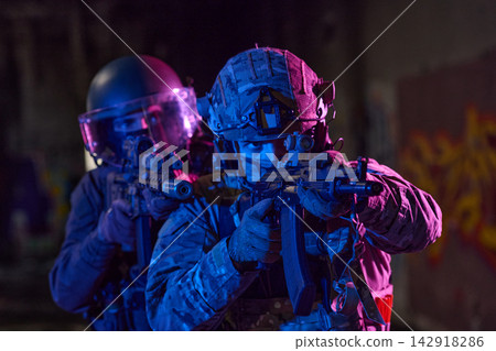 Tactical Soldiers in Urban Night Raid With Rifles and Riot Gear Team in Low Light 142918286