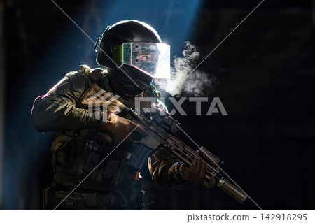 Armed Tactical Soldier In Helmet And Visor Holding Assault Rifle With Smoke And Dramatic Light Armed Tactical Soldier In Helmet And Visor Holding Assault Rifle With Smoke And Dramatic Light 142918295