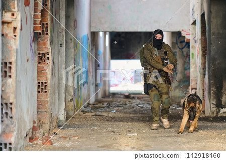 Armed Soldier With Military Dog On Urban Patrol Through Abandoned Building During Tactical Training 142918460
