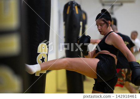 Female Kickboxing Workout In Gym Training With Heavy Bag And Boxing Gloves For Fitness Female Kickboxing Workout In Gym Training With Heavy Bag And Boxing Gloves For Fitness 142918461