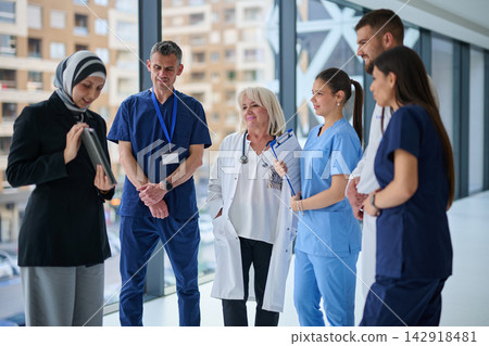 Medical team discusses patient care plan in modern hospital setting during afternoon Medical team discusses patient care plan in modern hospital setting during afternoon 142918481