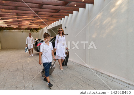 Family Leaving Luxury Villa With Luggage for Poolside Vacation Parents and Son Walking to Car Family Leaving Luxury Villa With Luggage for Poolside Vacation Parents and Son Walking to Car 142918490