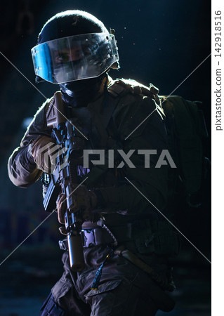 Armed Tactical Soldier With Visor Helmet Holding Rifle During Night Urban Operation 142918516
