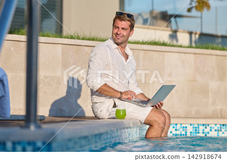 Man Working Remotely With Laptop by Poolside Enjoying Summer Vacation and Relaxed Business Man Working Remotely With Laptop by Poolside Enjoying Summer Vacation and Relaxed Business 142918674