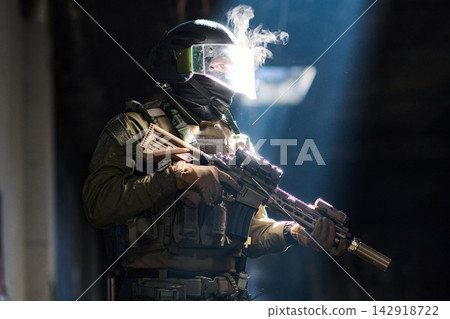 Tactical Soldier In Helmet With Visor Holding Assault Rifle In Dramatic Light Tactical Soldier In Helmet With Visor Holding Assault Rifle In Dramatic Light 142918722
