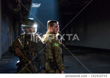 Two Tactical Soldiers Back-to-Back in Urban Ruin With Rifles and Protective Gear 142918735
