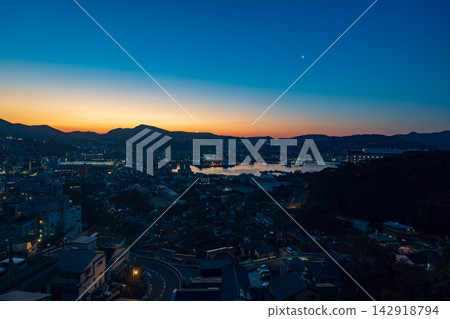 The early morning view from Sayama of Nagasaki city and Nagasaki harbor, with its gradient of colors reflecting the rising sun. The early morning view from Sayama of Nagasaki city and Nagasaki harbor, with its gradient of colors reflecting the rising sun. 142918794