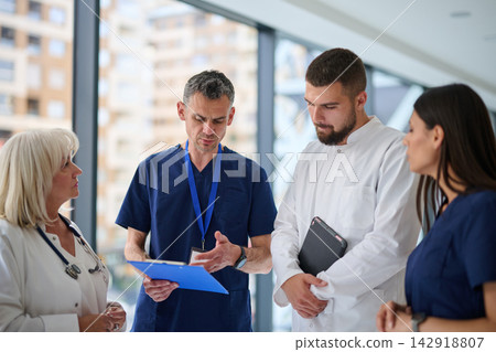 Medical team discusses patient care strategies in a clinic during daylight hours Medical team discusses patient care strategies in a clinic during daylight hours 142918807