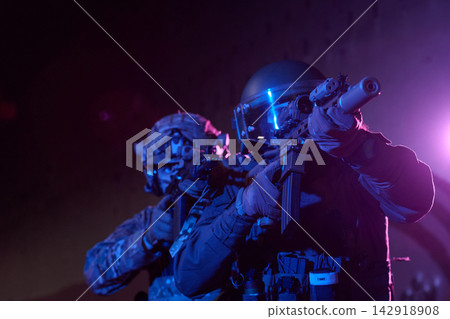 Special Forces Soldiers In Night Operation With Tactical Rifles And Ballistic Helmets Under Blue Light 142918908