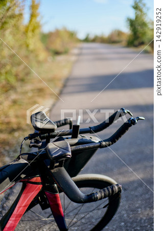 Road Bike With Aerobars On Quiet Country Road Ready For Triathlon Training And Long Distance Cycling Road Bike With Aerobars On Quiet Country Road Ready For Triathlon Training And Long Distance Cycling 142919252