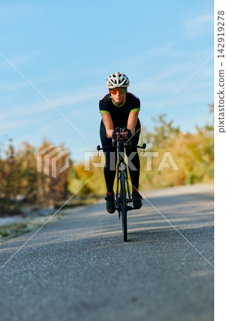 Focused Cyclist Training on Road Bike During Outdoor Endurance Ride in Clear Weather Focused Cyclist Training on Road Bike During Outdoor Endurance Ride in Clear Weather 142919278