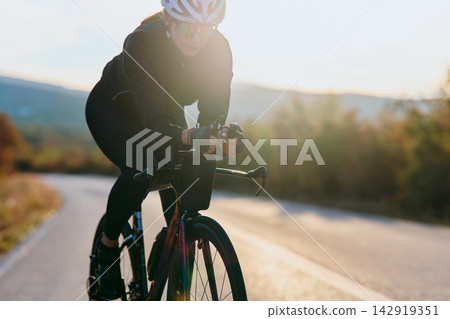 Female Cyclist Training On Road Bike At Sunset Outdoor Cycling Fitness And Endurance Ride Female Cyclist Training On Road Bike At Sunset Outdoor Cycling Fitness And Endurance Ride 142919351
