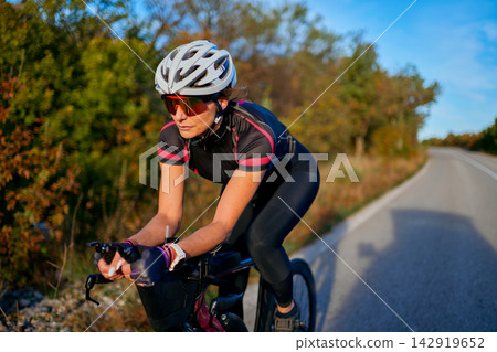 Female Road Cyclist Training on Scenic Countryside Route During Golden Hour Outdoor Cycling Workout Female Road Cyclist Training on Scenic Countryside Route During Golden Hour Outdoor Cycling Workout 142919652