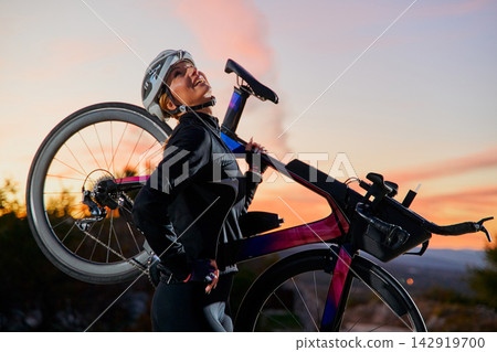 Female Cyclist Carrying Road Bike At Sunset Outdoors Smiling Strong Active Fitness Athlete Female Cyclist Carrying Road Bike At Sunset Outdoors Smiling Strong Active Fitness Athlete 142919700