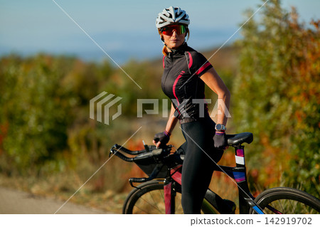 Female Cyclist With Road Bike Outdoors In Autumn Training Gear Looking Confident And Focused Female Cyclist With Road Bike Outdoors In Autumn Training Gear Looking Confident And Focused 142919702