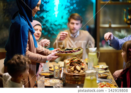 Muslim Family Sharing Dates and Iftar Meal Together Around a Festive Dinner Table Muslim Family Sharing Dates and Iftar Meal Together Around a Festive Dinner Table 142919808