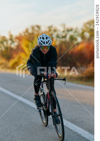 Female Cyclist Training on a Road Bike at Speed During Autumn Outdoor Endurance Ride Female Cyclist Training on a Road Bike at Speed During Autumn Outdoor Endurance Ride 142919928