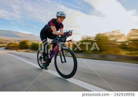 Female Road Cyclist Training at High Speed on Open Highway With Aerodynamic Bike Female Road Cyclist Training at High Speed on Open Highway With Aerodynamic Bike 142919956