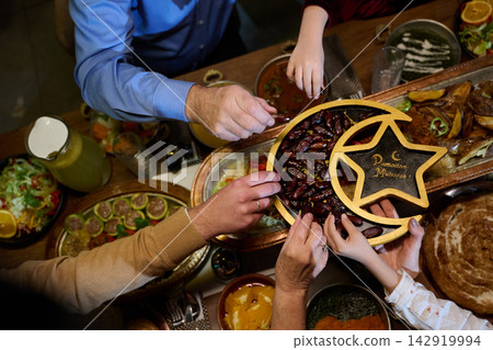 Family Sharing Dates at Iftar Dinner With Ramadan Mubarak Tray and Traditional Middle Eastern Foods Family Sharing Dates at Iftar Dinner With Ramadan Mubarak Tray and Traditional Middle Eastern Foods 142919994