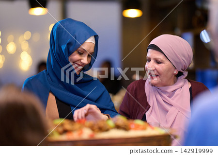 Muslim Women Sharing Food and Smiles Together During Family Celebration Dinner 142919999