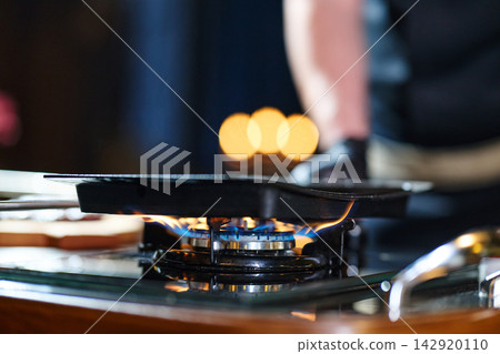 Close-Up Of Gas Stove Burner With Pan And Blue Flame On A Kitchen Stovetop Close-Up Of Gas Stove Burner With Pan And Blue Flame On A Kitchen Stovetop 142920110