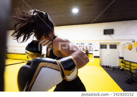 Female Boxer Training Intense Punching Workout In Bright Yellow Boxing Gym Female Boxer Training Intense Punching Workout In Bright Yellow Boxing Gym 142920152