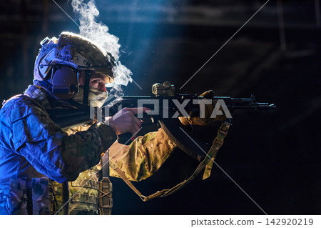 Soldier Aiming Assault Rifle in Tactical Gear With Helmet and Camouflage in Low Light Soldier Aiming Assault Rifle in Tactical Gear With Helmet and Camouflage in Low Light 142920219