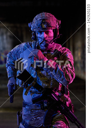 Armed Soldier In Tactical Gear With Rifle And Pistol Preparing For Night Urban Operation Armed Soldier In Tactical Gear With Rifle And Pistol Preparing For Night Urban Operation 142920233
