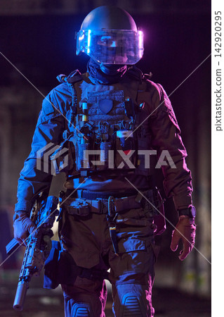 Tactical SWAT Officer in Riot Gear With Helmet Visor and Rifle Under Blue Purple Lighting Tactical SWAT Officer in Riot Gear With Helmet Visor and Rifle Under Blue Purple Lighting 142920295