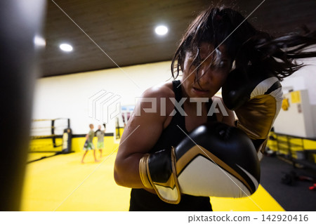 Female Boxer Training Intense Workout In Bright Boxing Gym With Gloves And Focus Female Boxer Training Intense Workout In Bright Boxing Gym With Gloves And Focus 142920416