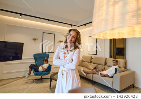 Smiling Woman With Family Relaxing In Modern Living Room With Sea View From Roooftop Terrace Smiling Woman With Family Relaxing In Modern Living Room With Sea View From Roooftop Terrace 142920428