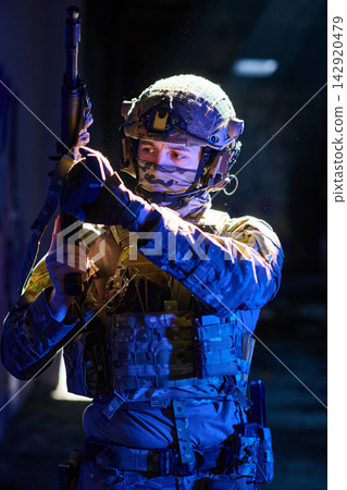 Young Soldier in Tactical Gear With Rifle Preparing for Night Urban Operation Young Soldier in Tactical Gear With Rifle Preparing for Night Urban Operation 142920479