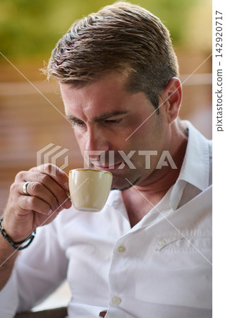 Thoughtful Man Drinking Coffee on Home Balcony Terrace Relaxing Morning Lifestyle Portrait Thoughtful Man Drinking Coffee on Home Balcony Terrace Relaxing Morning Lifestyle Portrait 142920717