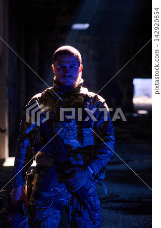 Tactical Soldier In Camouflage Gear Holding Rifle Under Dramatic Night Light In Urban Ruins Tactical Soldier In Camouflage Gear Holding Rifle Under Dramatic Night Light In Urban Ruins 142920854