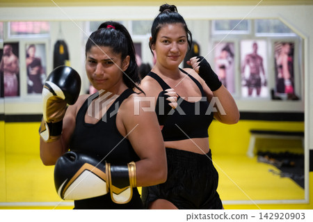 Two Women Boxing Training Together in Gym Practicing Fitness and Self-Defense Sparring Session Two Women Boxing Training Together in Gym Practicing Fitness and Self-Defense Sparring Session 142920903