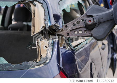 Emergency Rescue Team Using Hydraulic Cutter (Jaws of Life) To Extricate Occupant From Crashed Car Emergency Rescue Team Using Hydraulic Cutter (Jaws of Life) To Extricate Occupant From Crashed Car 142920948