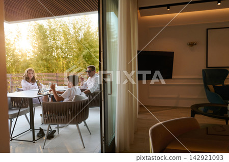 Family Relaxing on Modern Home Balcony Terrace With Parents and Child Enjoying Afternoon Outdoors Family Relaxing on Modern Home Balcony Terrace With Parents and Child Enjoying Afternoon Outdoors 142921093