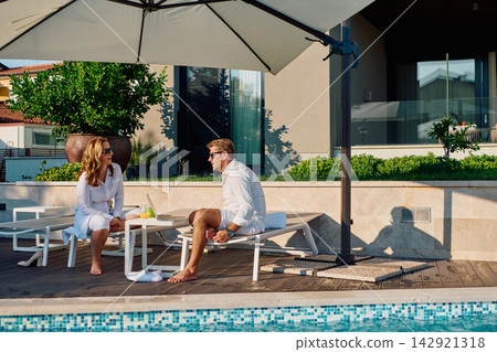 Couple Enjoying Breakfast by Pool on Luxury Outdoor Terrace With Sun Umbrella and Relaxation Couple Enjoying Breakfast by Pool on Luxury Outdoor Terrace With Sun Umbrella and Relaxation 142921318