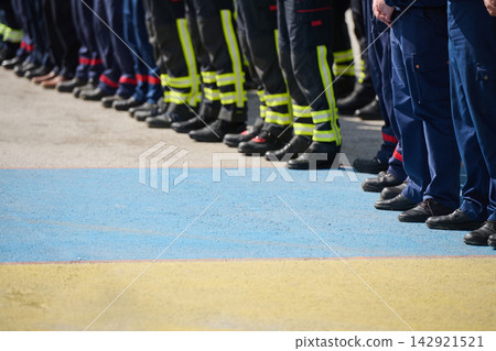 Firefighters And Emergency Responders Standing In Line Wearing Uniforms And Reflective Boots At Ceremony Firefighters And Emergency Responders Standing In Line Wearing Uniforms And Reflective Boots At Ceremony 142921521
