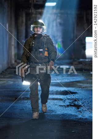 Tactical Soldier In Helmet And Body Armor Walking Through Abandoned Urban Building With Rifle Tactical Soldier In Helmet And Body Armor Walking Through Abandoned Urban Building With Rifle 142921592