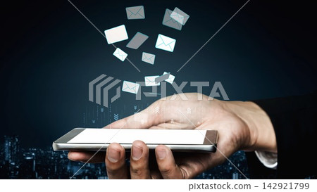 Hand Holding Smartphone with Floating Email Icons and Night Cityscape Background Representing Communication and Technology Concept. Entropy Hand Holding Smartphone with Floating Email Icons and Night Cityscape Background Representing Communication and Technology Concept. Entropy 142921799