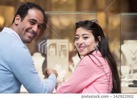 Middle Eastern couple shopping for wedding rings with family and friends at a jewelry store 142922002