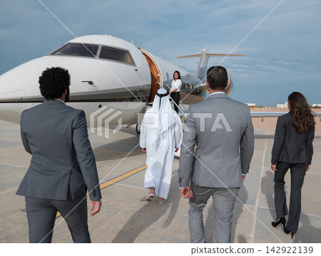Middle Eastern business team boarding private jet for corporate travel and luxury executive trip 142922139