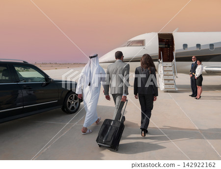Middle Eastern business team boarding private jet at desert airport for executive travel 142922162