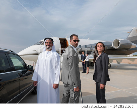 Middle Eastern business team arriving at private jet on airport tarmac for executive travel Middle Eastern business team arriving at private jet on airport tarmac for executive travel 142922165