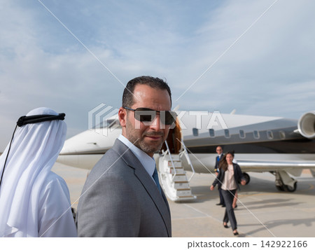Middle Eastern business team boarding private jet on tarmac for executive corporate travel and meetings Middle Eastern business team boarding private jet on tarmac for executive corporate travel and meetings 142922166